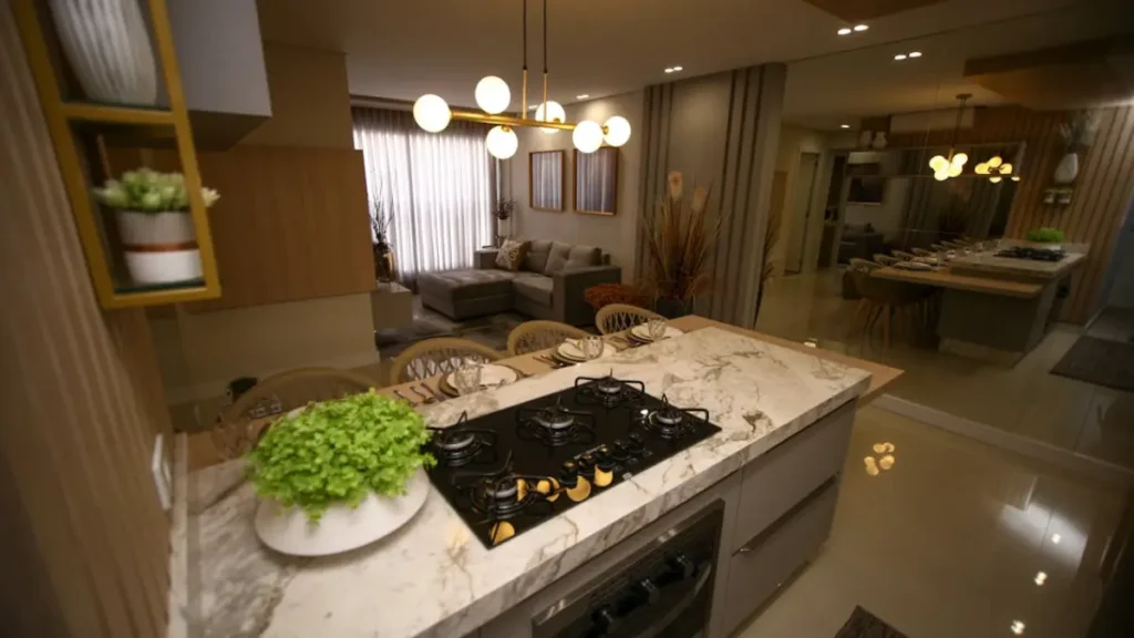 Vista panoramica de cozinha integrada com sala de estar, o ambiente demonstra a mescla de luz fria e luz quente e como integra-la para ter um aconchego.